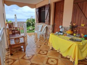 a room with a table with a yellow table cloth at KANALU Land in Bouillante