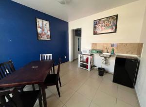 a dining room with a table and a blue wall at STUDiOS RAYON in Morelia