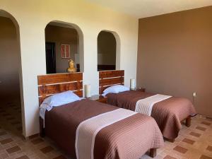 two beds in a hotel room with two at Casa Amelia Hotel & Boutique in Zacatlán