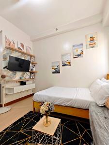 a bedroom with a bed and a tv on a wall at R&N Trees Residence in Manila