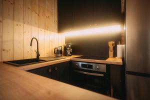 a kitchen with a sink and a stove at Chata u Karla in Rudná pod Pradědem +6 photos