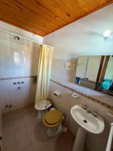 a bathroom with a toilet and a sink and a mirror at El Amanecer in Mina Clavero