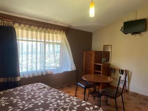 a bedroom with a bed and a table and a window at Casa Amelia Hotel & Boutique in Zacatlán