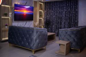 a waiting room with two couches and a flat screen tv at Emerald Apartments in Lagos +13 photos