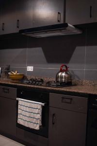 a kitchen with a stove with a tea kettle on it at Emerald Apartments in Lagos