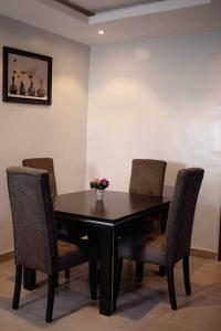 a dining room table and chairs with flowers on it at Emerald Apartments in Lagos