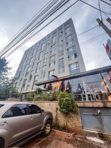 a car parked in front of a tall building at Thesh Home at Tsavo Sunset 2 ,Thindigua Kiambu Road in Kiambu