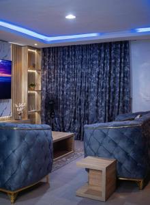 a living room with two couches and a curtain at Emerald Apartments in Lagos