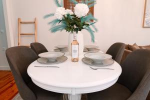 a white table with a vase of flowers on it at Dolce Casa in Corfu +3 photos