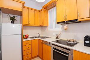 a kitchen with wooden cabinets and a white refrigerator at Dolce Casa in Corfu