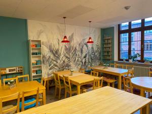 a restaurant with tables and chairs and a mural on the wall at Steffis Hostel Heidelberg in Heidelberg