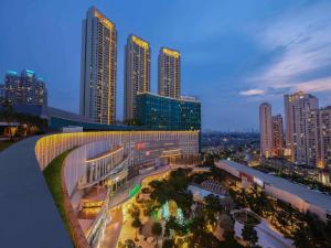 a view of a city at night with tall buildings at Pullman Jakarta Central Park in Jakarta