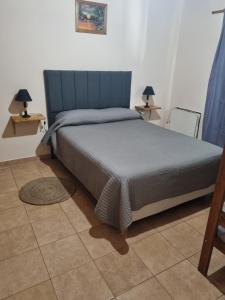 a bedroom with a bed with a blue headboard and two lamps at Refugio del Valle - Uspallata in Uspallata