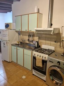 a kitchen with a stove and a washing machine at Refugio del Valle - Uspallata in Uspallata +4 photos