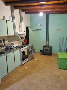 a kitchen with a stove and a washing machine at Refugio del Valle - Uspallata in Uspallata