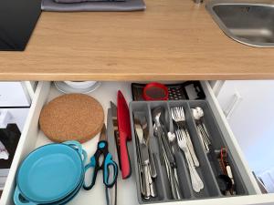 a drawer filled with utensils under a kitchen counter at Casa Tua An der Weinstraße in Neustadt an der Weinstraße