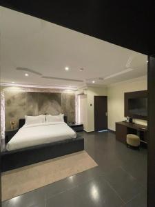 a bedroom with a large bed and a desk at Hirolagos in Bamgbose