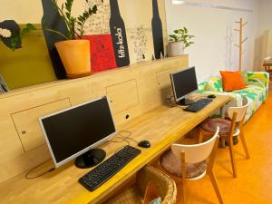 a desk with a computer and two monitors on it at Steffis Hostel Heidelberg in Heidelberg
