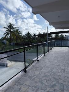 a balcony with a view of the water and palm trees at Aparta Hotel Mi Dulce Amanecer 2 in Cabrera