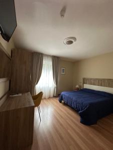 a bedroom with a blue bed and a window at Hotel Sole in Maiori