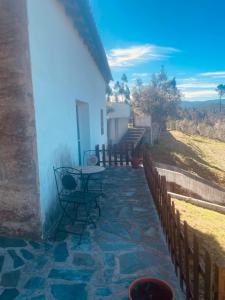 a patio of a white house with a table and chairs at Casa Água in Lamas