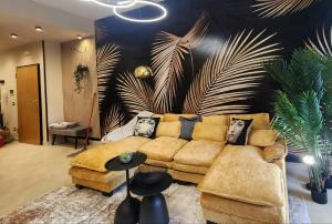 a living room with a couch and a palm wall at Park & Seafront Pescara in Montesilvano