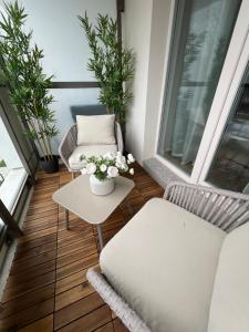 a balcony with two chairs and a table and flowers at SPV Rentals Premium Apartament Wołoska 3 in Warsaw