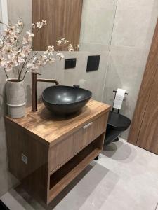 a bathroom with a black bowl sink on a wooden counter at SPV Rentals Premium Apartament Wołoska 3 in Warsaw