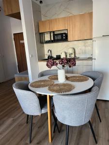 a kitchen and dining room with a table and chairs at SPV Rentals Premium Apartament Wołoska 3 in Warsaw