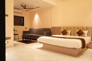 a bedroom with a bed and a couch at Shri Prasad Executive in Pandharpur