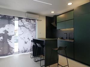 a kitchen with a black counter and stools in it at Apartment Bogunovic in Bar