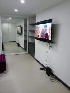 a room with a flat screen tv on a wall at Nova MSuites Viveiro in Viveiro