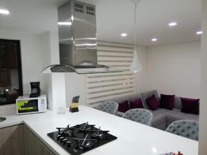 a kitchen with a stove top oven next to a couch at Nova MSuites Viveiro in Viveiro