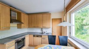 a kitchen with wooden cabinets and a table and a window at Ruhiges und gemütliches Appartment mit Garten in Herford