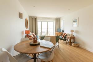 a living room with a wooden table and chairs at The Beach House & Porth Sands Apartments in Newquay