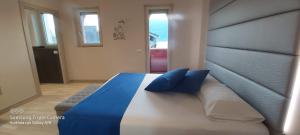 a large bed with blue pillows in a bedroom at Hotel Danieli La Castellana lago di Garda in Brenzone sul Garda