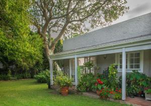 a house with flowers and plants in a yard at Lloyd Road Cottage in Port Elizabeth