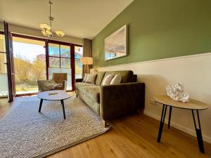 a living room with a couch and a table at Oewern Diek App 52 in Wustrow
