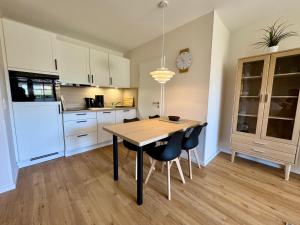 a kitchen with a dining room table and chairs at Oewern Diek App 52 in Wustrow