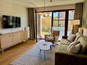 a living room with a couch and a table at Oewern Diek App 52 in Wustrow