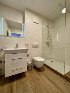 a bathroom with a sink and a toilet and a shower at Oewern Diek App 52 in Wustrow +10 photos