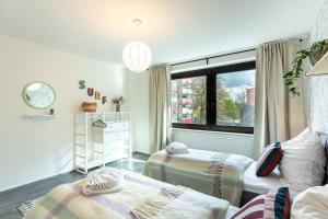 a small room with two beds and a window at LEVEL22 ! Groß & Modern, Parkplatz, Balkon, Küche in Leverkusen