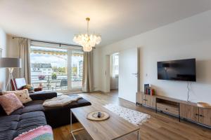 a living room with a couch and a tv at LEVEL22 ! Groß & Modern, Parkplatz, Balkon, Küche in Leverkusen