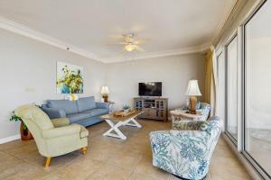 a living room with a blue couch and chairs at Beachfront Condo with Balcony Pools and Gym in Destin