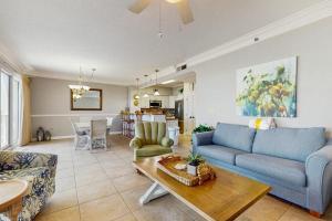 a living room with a blue couch and a table at Beachfront Condo with Balcony Pools and Gym in Destin