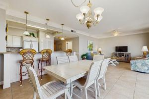 a dining room and kitchen with a table and chairs at Beachfront Condo with Balcony Pools and Gym in Destin