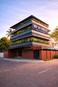 a building with a sign that reads waitiest at W H Nest Hostel in Cochin