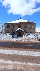 a building on the side of a road with snow at Kutchak AparanQ in Kʼuchʼak