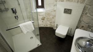 a bathroom with a shower and a toilet and a sink at Kasr-i Nehroz Hotel in Midyat