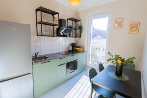a small kitchen with a table and a refrigerator at BetterBeds Wilhelm City in Brandenburg an der Havel